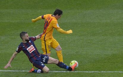 David Junca del Eibar intenta frenar la jugada de Lionel Messi.