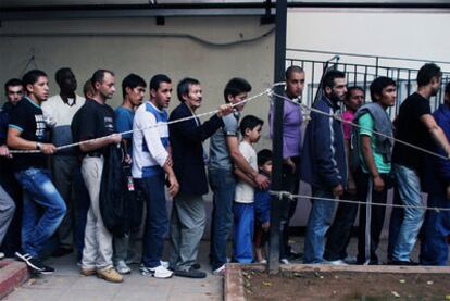 Decenas de inmigrantes aguardan a las puertas de un comedor de beneficencia en Atenas, en octubre.
