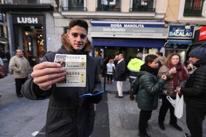 Luis mostrando su compra tras dos horas y media de cola en Doña Manolita.