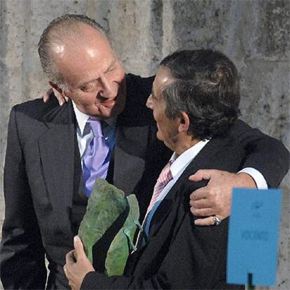 Don Juan Carlos abraza a Miguel Delibes de Castro tras entregarle el galardón concedido a su padre.