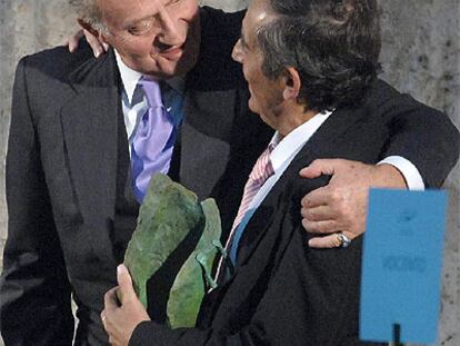 Don Juan Carlos abraza a Miguel Delibes de Castro tras entregarle el galardón concedido a su padre.
