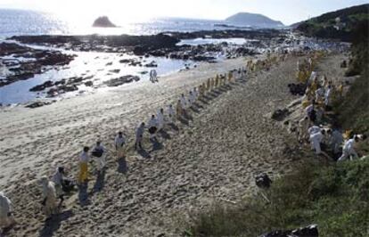 Decenas de voluntarios limpian de chapapote la playa de Canesol, en la isla de Ons.