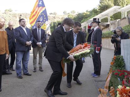 El presidente de la Generalitat, Carles Puigdemont, acompa&ntilde;ado por el vicepresidente, Oriol Junqueras, durante la ofrenda floral con motivo del 76 aniversario del fusilamiento de Lluis Companys. 