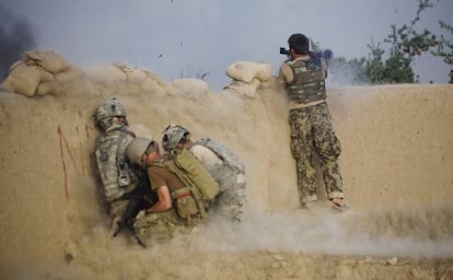 Un soldado afgano dispara un lanzacohetes, junto a tres militares estadounidenses a cubierto, en Kandahar, en julio de 2010.