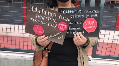 Una madre muestra dos carteles durante una protesta rente al instituto de Rejas.