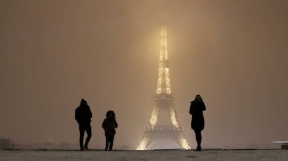 Turistas caminan sobre la nieve cerca de la Torre Eiffel en París (Francia).