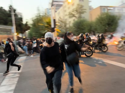 Dos mujeres huyen de la policía durante la protesta en Teherán, este lunes. Unos 300 manifestantes, según Efe, se congregaron en el bulevar Keshavarz, en el centro de la capital, y corearon lemas contra los líderes iraníes.