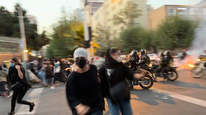 Dos mujeres huyen de la policía durante una protesta en Teherán el 20 de septiembre de 2022, tras la muerte de Yina Masha Amini.