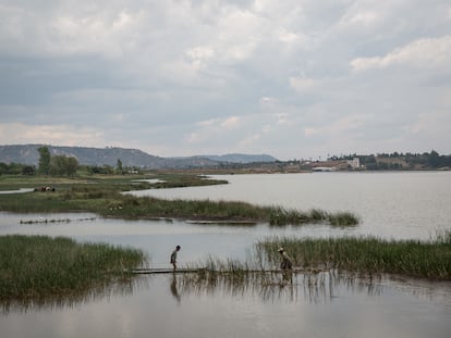 Un adulto y un niño trabajan en el agua en Antananarivo, Madagascar.