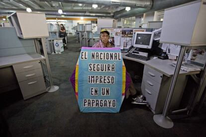 Un periodista sostiene una cometa en la que se puede leer 'El Nacional seguirá impreso en un papagayo' en la sala de prensa del periódico, el 14 de diciembre de 2018. El medio antigubernamental dejó de publicar su edición en papel debido a la presión del Gobierno y la escasez de papel.