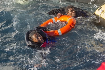 Dos inmigrantes se agarran a un flotador al ser rescatados por Salvamento Marítimo, en el Estrecho de Gibraltar. Las condiciones de las pateras y cayucos que emplean los indocumentados para tratar de cruzar la frontera son precarias. En ocasiones, llegan a emplear balsas hinchables. Muchas naufragan.