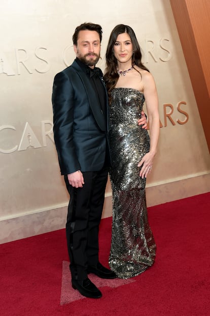 Kieran Culkin, ganador del Oscar a mejor actor de reparto por 'A Real Pain', de azul marino y negro de Zegna, junto a su mujer, la actriz Jazz Charton, con un vestido de lentejuelas palabra de honor, uno de los escotes más repetidos en la alfombra roja de los Oscar de este año.