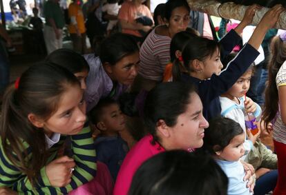 Mujeres y niños se agolpan para escuchar la homilía durante el homenaje a las víctimas de la masacre.