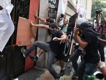 Manifestantes intentan romper una puerta de acceso ayer, martes, durante los disturbios en Río de Janeiro.