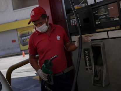Un trabajador dispensa gasolina con guantes y mascarilla en Caracas el pasado 16 de marzo.
