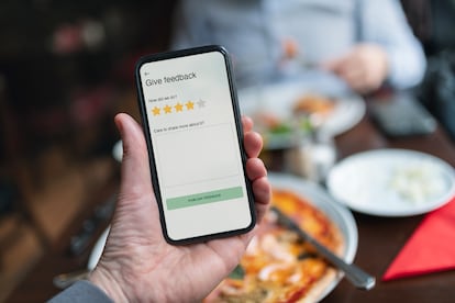 Person holding smart phone with restaurant rating app