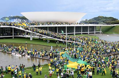 TOPSHOT - Supporters of Brazilian former President Jair Bolsonaro hold a demonstration at the Esplanada dos Ministerios in Brasilia on January 8, 2023. - Hundreds of supporters of Brazil's far-right ex-president Jair Bolsonaro broke through police barricades and stormed into Congress, the presidential palace and the Supreme Court Sunday, in a dramatic protest against President Luiz Inacio Lula da Silva's inauguration last week. (Photo by EVARISTO SA / AFP)