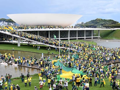 TOPSHOT - Supporters of Brazilian former President Jair Bolsonaro hold a demonstration at the Esplanada dos Ministerios in Brasilia on January 8, 2023. - Hundreds of supporters of Brazil's far-right ex-president Jair Bolsonaro broke through police barricades and stormed into Congress, the presidential palace and the Supreme Court Sunday, in a dramatic protest against President Luiz Inacio Lula da Silva's inauguration last week. (Photo by EVARISTO SA / AFP)