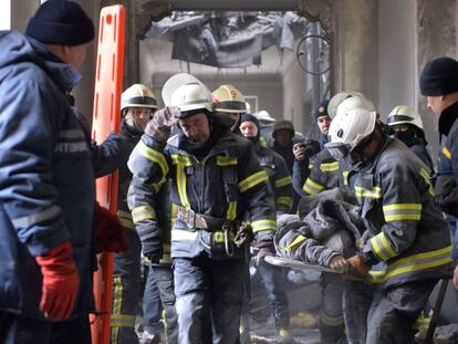 Personal de emergencias rescata el cuerpo de un hombre tras el ataque ruso en el Ayuntamiento de Járkov (Ucrania).
