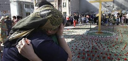 Dos mujeres lloran en lo que era el gimnasio de la escuela Nº 1 de Beslán, en Osetia del Norte