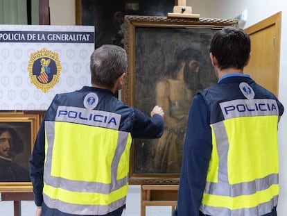 Dos agentes observan las pinturas atribuidas a Diego Velázquez y a Tiziano, pero que eran falsificaciones que habían salido al mercado.