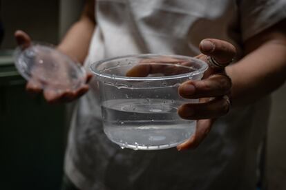 Lucina Leo, vecina de la colonia del valle, sostiene una muestra de agua contaminada en su domicilio. 