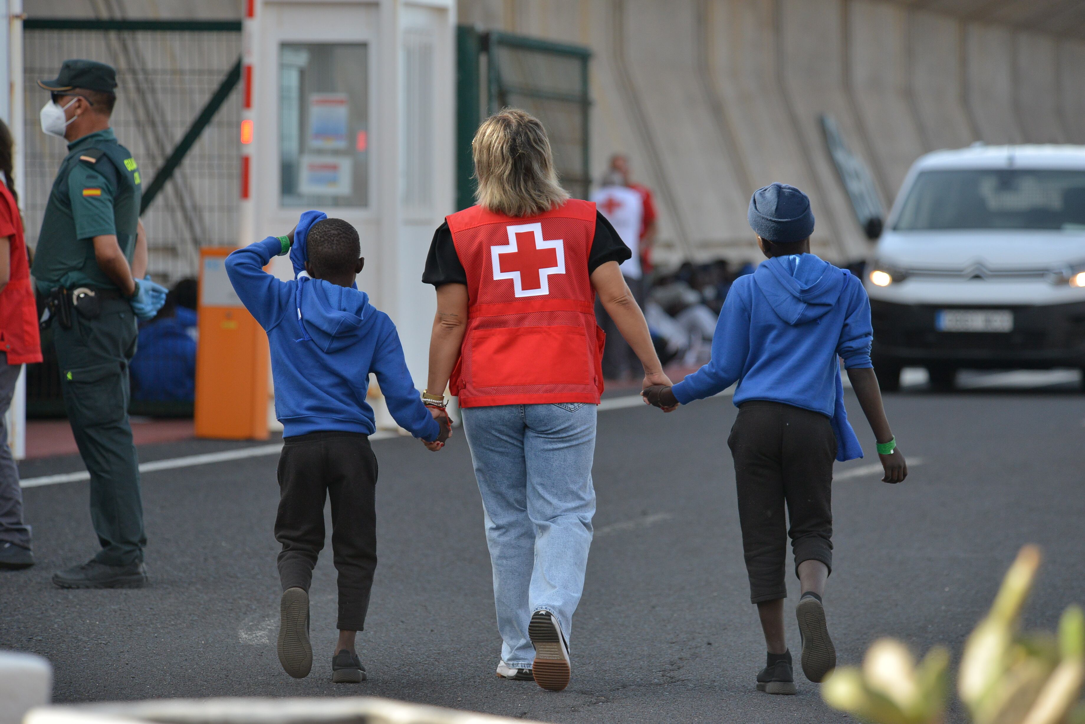 Un miembro de la Cruz Roja escoltaba a dos de los menores en el puerto de La Estaca en El Hierro, el 11 de septiembre. 