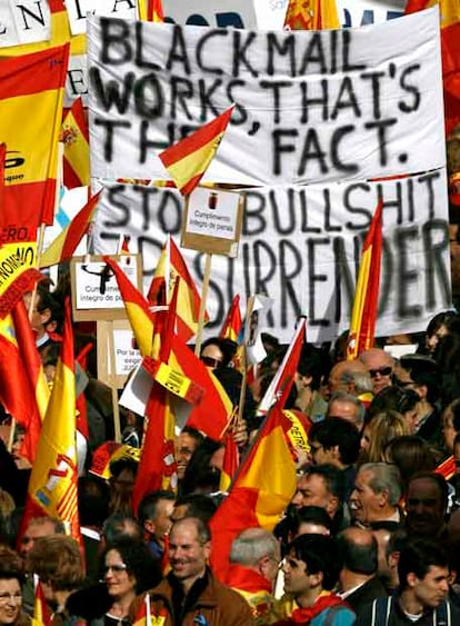 Varias personas cogen banderas de España momentos antes de participar en la manifestación convocada por el PP en Madrid, en protesta por la concesión de prisión atenuada al preso de ETA José Ignacio de Juana Chaos.