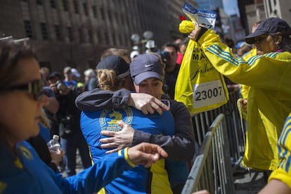 Unas corredoras se abrazan después de recoger sus bolsas que dejaron abandonadas tras producirse las explosiones en el Maratón de Boston. Las autoridades de Boston han pedido a los ciudadanos que envíen cuanto antes las fotos y vídeos que pudieran tomar en los momentos previos y posteriores a las explosiones.