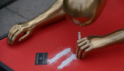 Una estatuilla del tamaño de un humano a cuatro patas en el suelo esnifando cocaína casi frente por frente al teatro Dolby.
