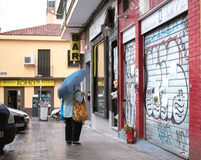 Una vecina del barrio de Prosperidad observa los mensajes de despedida colgados en la puerta de la pastelería Valle Olid.