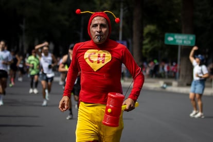Un hombre caracterizado de 'El Chapulin Colorado' cruza Paseo de la Reforma durante el Maratón.