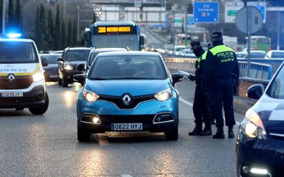 La policía municipal para un vehículo con matrícula par en el acceso a Madrid por la A-2.
