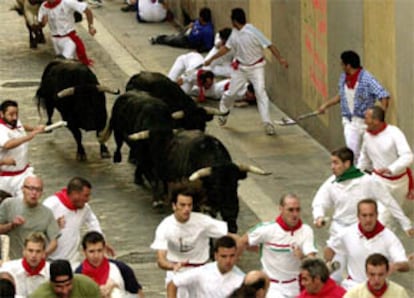 Varios corredores en el final del tramo de Santo Domingo durante el sexto encierro de los Sanfermines 2002.