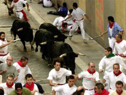 Varios corredores en el final del tramo de Santo Domingo durante el sexto encierro de los Sanfermines 2002.