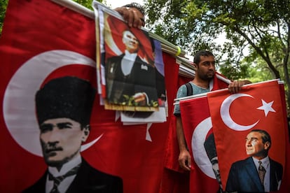 Unos vendedores de banderas sostienen retratos de Mustafa Kemal Ataturk, fundador de la Turquía moderna, durante una manifestación contra la condena a 25 años de cárcel de un diputado del partido CHP, en Ankara (Turquía).