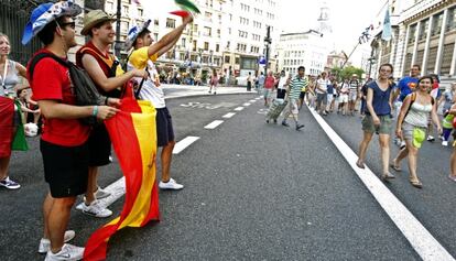 Decenas de jóvenes peregrinos pasean por una céntrica calle de Madrid.