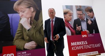 Peer Steinbr&uuml;ck, entre dos carteles electorales de su partido.