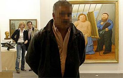 El ministro de Fomento, Francisco Álvarez-Cascos, acompañó el martes 10 a su novia, María Porto, a controlar los últimos detalles del <i>stand</i> que la galería Marlborough que ella dirige ocupa en Arco 2004. La XXIII Feria Internacional de Arte Contemporáneo fue inaugurada por la reina Sofía un día después. En primer plano, un guardaespaldas pretende distraer el objetivo del fotógrafo.