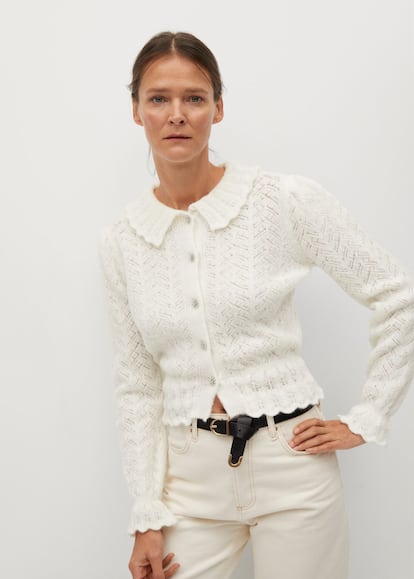 Chaqueta de punto calado, con cuello bebé, botones joya y en un delicado color blanco. Es la prenda que buscaban todas las aficionadas al estilo romántico. Consíguela en Mango por 29,99 euros.