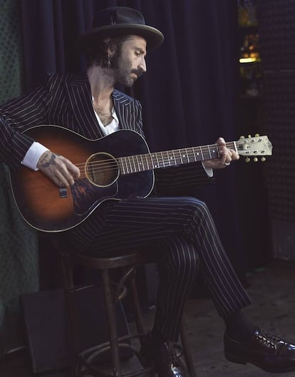 Leiva viste un traje de mil rayas de Dolce & Gabbana, camisa con cuello mao de The Kooples, zapatos de Church’s y sombrero de Sombrerería Yoqs.