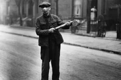 Un trabajador de la sanidad pública británica pulveriza un líquido contra la gripe en Reino Unido en 1920.