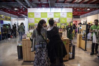 Dos jóvenes compran en uno de los puestos de la feria.