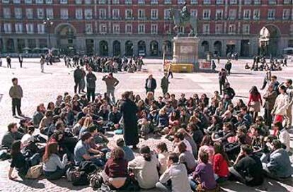 Un grupo de alumnos universitarios escucha la lección impartida por su profesor en la plaza Mayor como protesta contra la guerra.