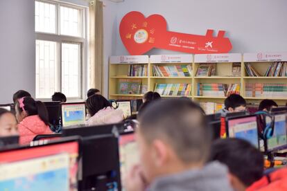 Un grupo de niños asiste a una clase de informática en el aula Firefly del colegio Yulong Town. El proyecto dota a los centros escolares de mobiliarios, ordenadores conectados a Internet y libros.