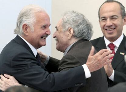 Carlos Fuentes abraza a Gabriel García Márquez ante el aplauso del presidente Felipe Calderón durante la celebración de sus 80 años, en noviembre de 2008.