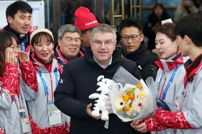 El presidente del Comité Olímpico Internacional, Thomas Bach, posa con voluntarios del equipo de los Juegos Olímpicos a su llegada a la estación de Jinbu en Pyeongchang (Corea del Sur).