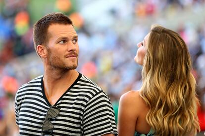 Tom Brady y de espaldas su mujer Gisele Bundchen.