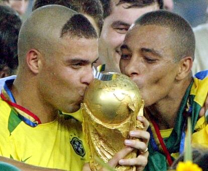 30 de junio de 2002. Los brasileños Ronaldo, izquierda, y Kléberson besan la Copa del Mundo tras ganar 2-0 a Alemania en la final jugada en el estadio Internacional de Yokohama (Japón). Brasil, derrotada por Francia en la final de 1998, se imponía ante una estupenda Alemania con dos goles de Ronaldo. La 'canariha' conseguía su quinto título.