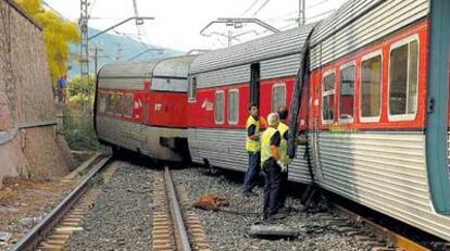 Tres operarios comprueban el estado de los vagones del Talgo que se salieron de la vía en Alcover (Tarragona).